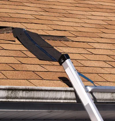 Burroughs Roofing can repair roof damage like the missing tiles shown in this picture of a roof needing repair